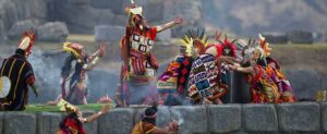 Farverigt klædte deltagere udfører en traditionel ceremoni i Cusco
